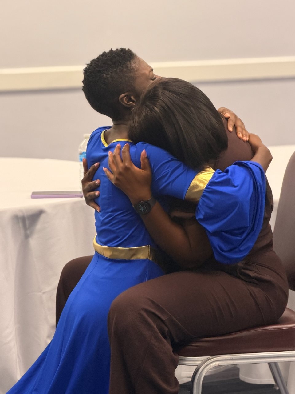 Two attendees sharing an embrace at Dwell 2026